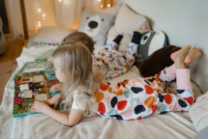kislány mesét olvas 4babies tipegő hálózsákban